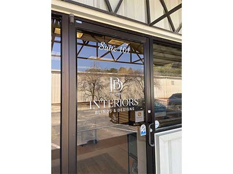 Glass door with the Interiors Blinds & Designs company logo